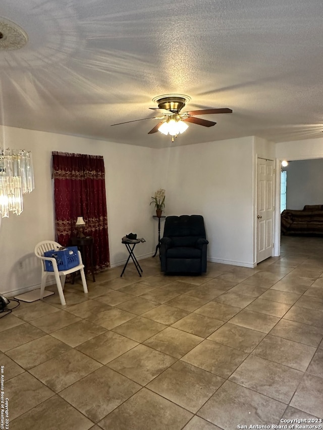 unfurnished room with light tile floors, ceiling fan, and a textured ceiling