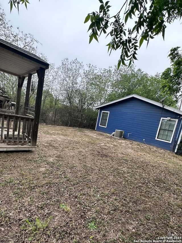 view of yard featuring central AC unit and a wooden deck