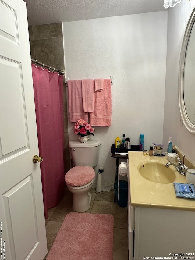 bathroom featuring tile floors, toilet, a textured ceiling, and vanity