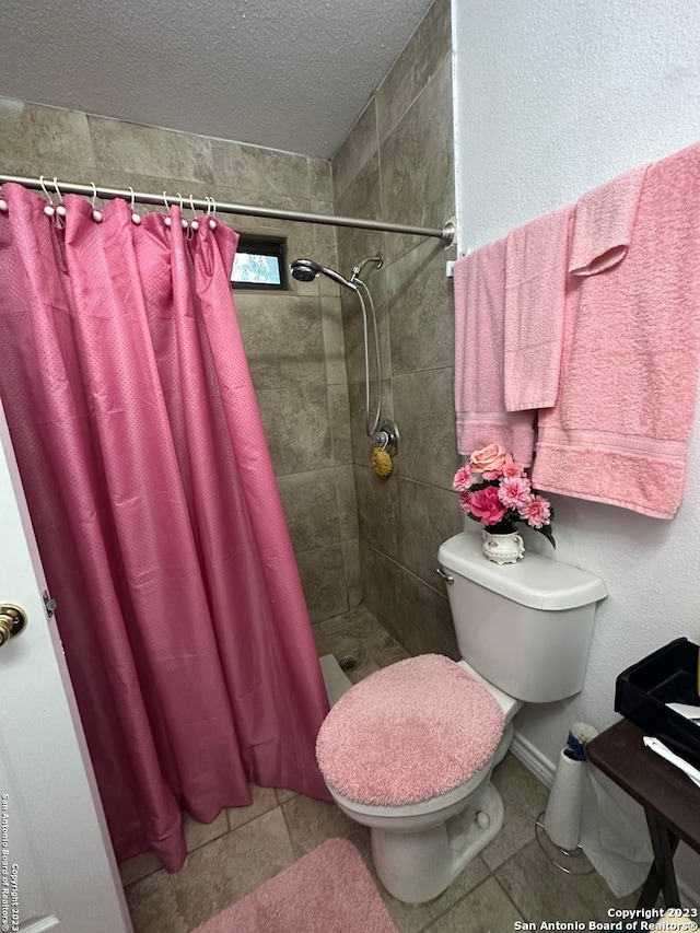 bathroom with tile flooring, a textured ceiling, a shower with shower curtain, and toilet