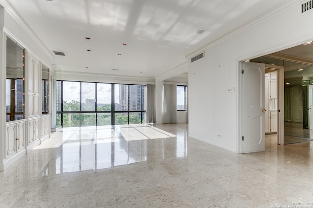 tiled empty room featuring crown molding