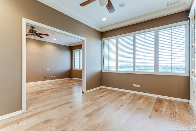 unfurnished room featuring ornamental molding, ceiling fan, a wealth of natural light, and light wood-type flooring