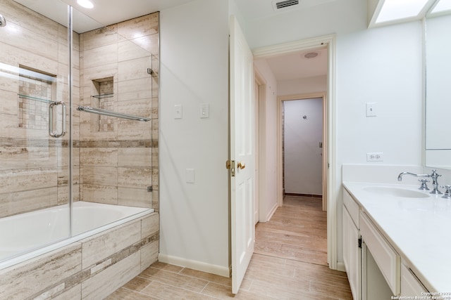 bathroom featuring vanity, enclosed tub / shower combo, and hardwood / wood-style flooring