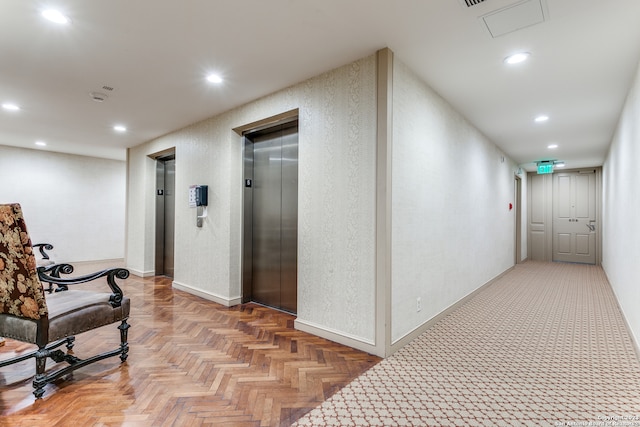 corridor with light parquet floors and elevator