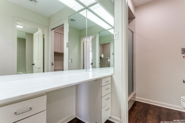 bathroom with vanity with extensive cabinet space, toilet, an enclosed shower, and wood-type flooring