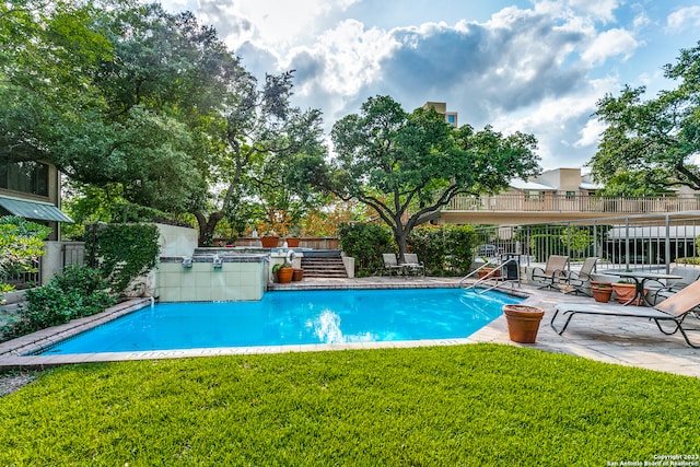 view of swimming pool with a patio area and a yard