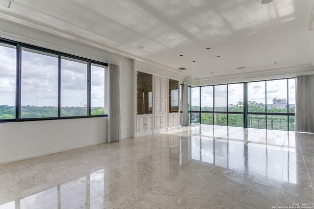 spare room featuring light tile floors and ornamental molding