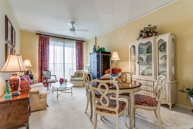 dining room with light carpet, crown molding, and ceiling fan