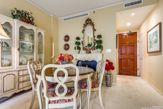 carpeted dining area with crown molding and a fireplace