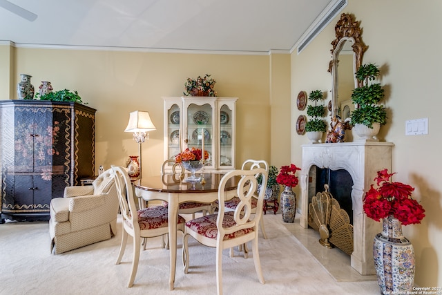 carpeted dining space featuring ornamental molding and a fireplace