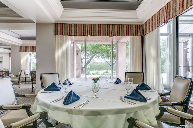 dining area with carpet floors, ornamental molding, and a tray ceiling