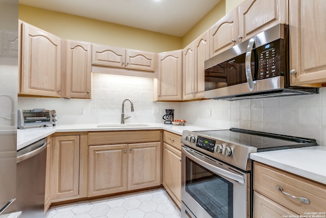 kitchen featuring light brown cabinetry, sink, light tile floors, stainless steel appliances, and tasteful backsplash