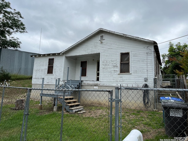 back of house with a lawn