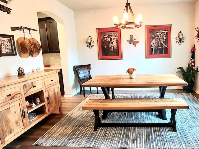 dining area with a chandelier and dark wood-type flooring