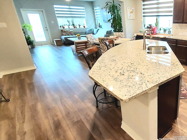 kitchen with dark hardwood / wood-style flooring, a breakfast bar, and a wealth of natural light