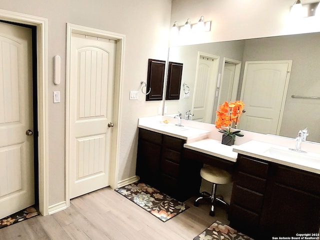 bathroom with double vanity and wood-type flooring