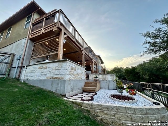 property exterior at dusk featuring a lawn