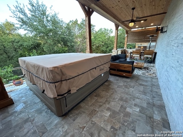 view of terrace with an outdoor hangout area, ceiling fan, and a hot tub