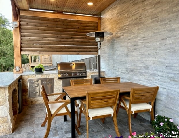 dining area featuring wood ceiling and dark tile floors