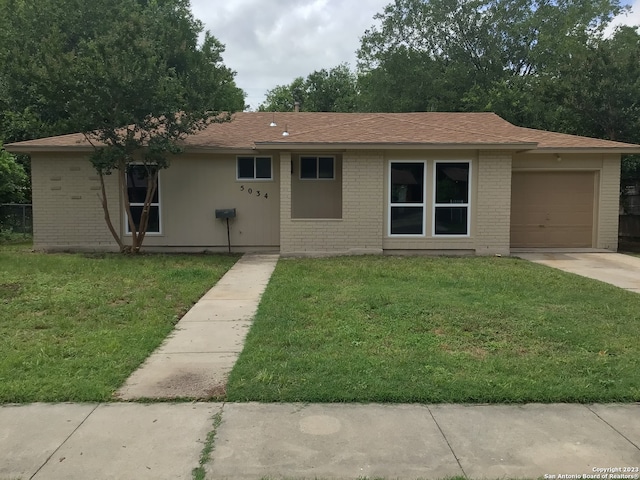 ranch-style home with a front lawn and a garage