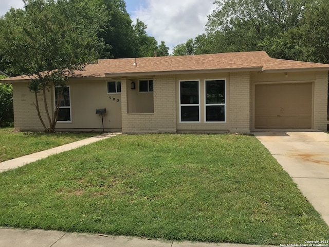 single story home featuring a front lawn and a garage