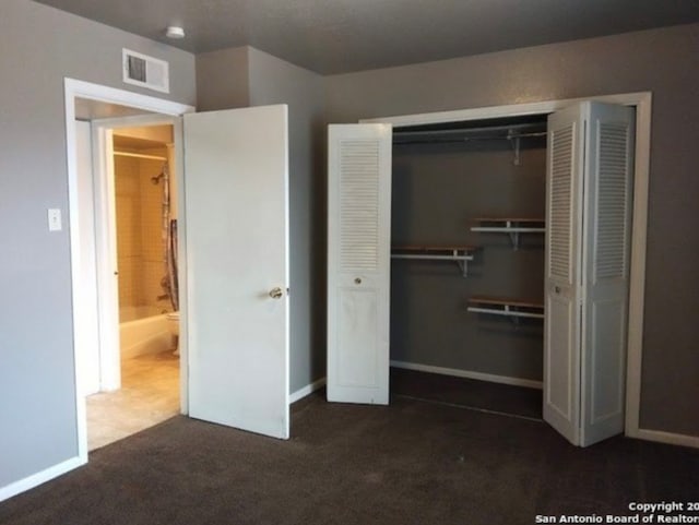 unfurnished bedroom with a closet and dark carpet