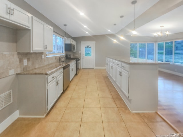 kitchen featuring white cabinets, hanging light fixtures, stainless steel dishwasher, light tile patterned floors, and black range with electric cooktop