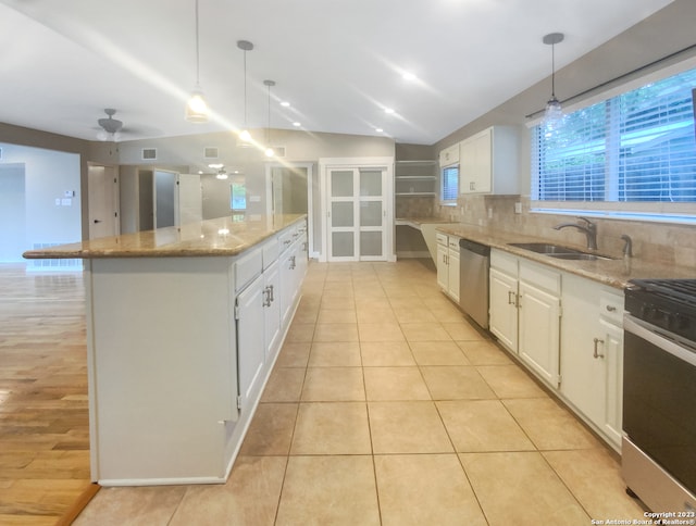 kitchen featuring white cabinets, a kitchen island, sink, and appliances with stainless steel finishes