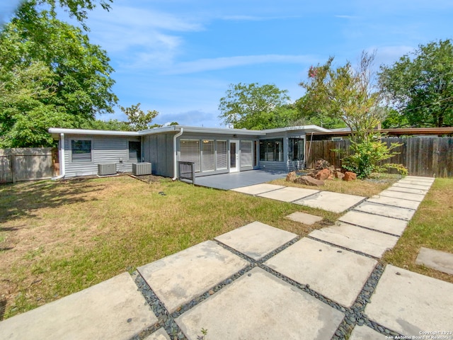 back of house with a lawn, central air condition unit, and a patio