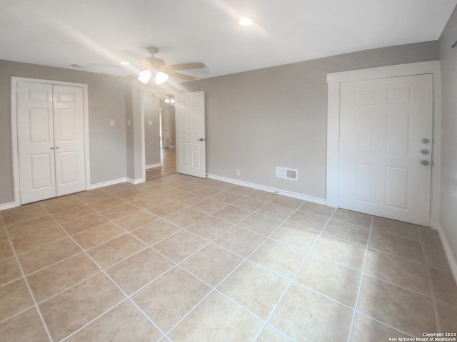 unfurnished bedroom featuring ceiling fan, a closet, and light tile patterned flooring