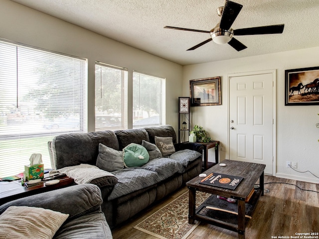 living room featuring a textured ceiling, dark hardwood / wood-style floors, and ceiling fan