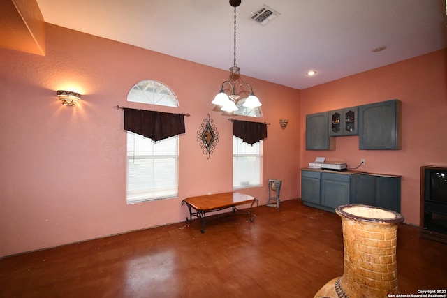 interior space featuring dark hardwood / wood-style floors, decorative columns, and a chandelier