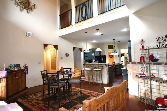 dining space featuring a high ceiling and dark hardwood / wood-style floors