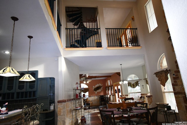 interior space featuring ceiling fan, a high ceiling, and dark hardwood / wood-style floors