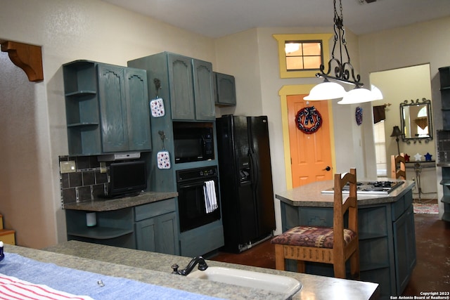 kitchen with hanging light fixtures, black appliances, a notable chandelier, sink, and tasteful backsplash