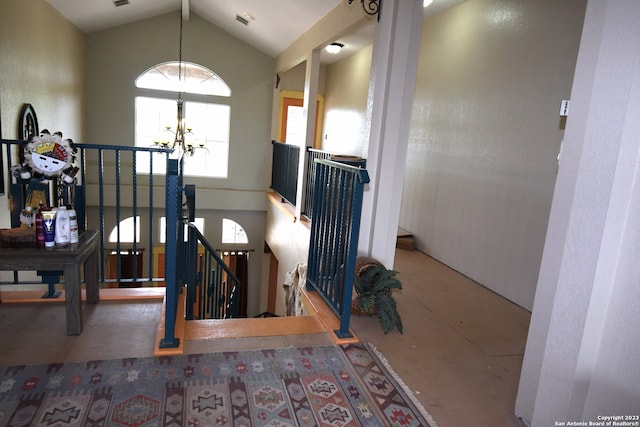 stairs with high vaulted ceiling and a notable chandelier