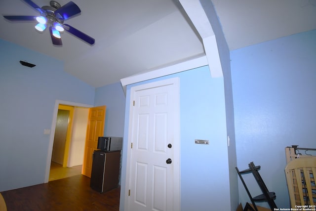 corridor with dark hardwood / wood-style flooring and vaulted ceiling