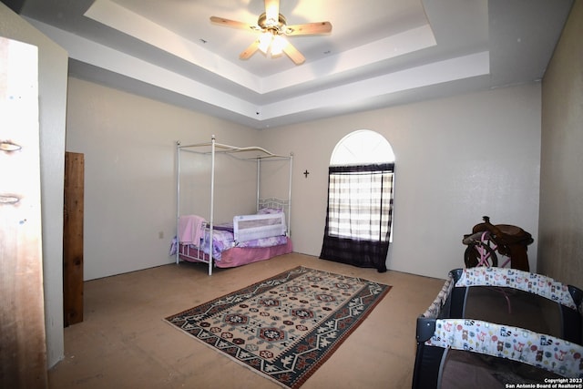 bedroom with ceiling fan and a tray ceiling