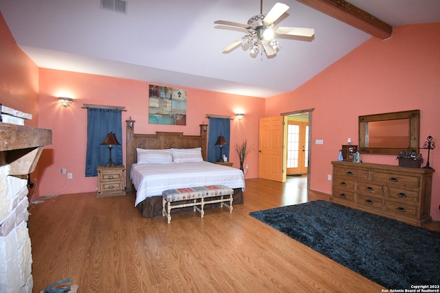 bedroom featuring ceiling fan, a fireplace, beamed ceiling, high vaulted ceiling, and light hardwood / wood-style flooring