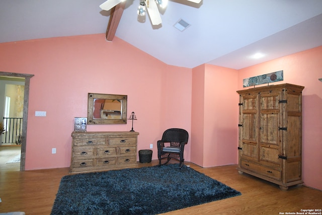 living area featuring vaulted ceiling with beams, ceiling fan, and light wood-type flooring