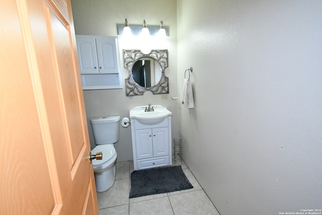 bathroom featuring vanity, tile floors, and toilet