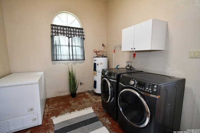 clothes washing area with washer hookup, cabinets, electric water heater, and washing machine and clothes dryer