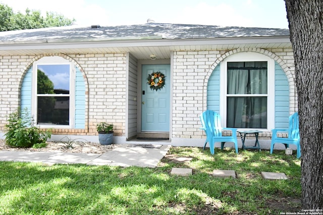 property entrance featuring a lawn