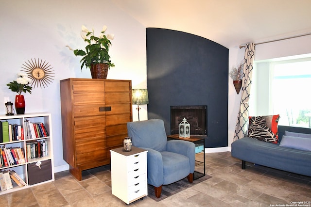 living area featuring light tile flooring and vaulted ceiling