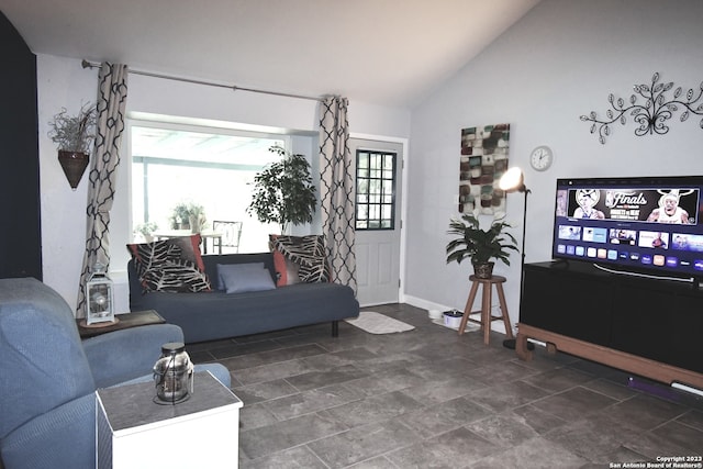 living room with dark tile floors and vaulted ceiling