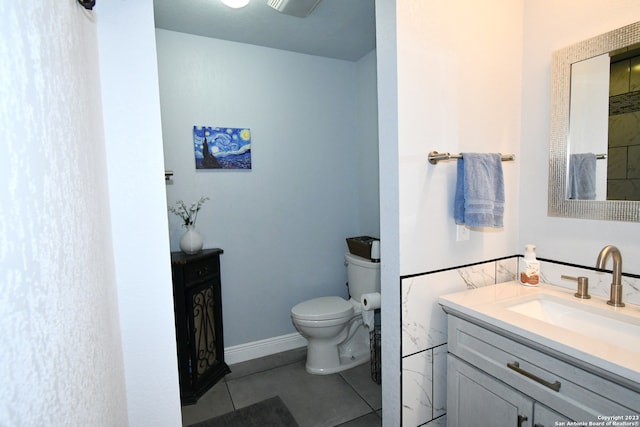 bathroom featuring toilet, tile floors, and vanity