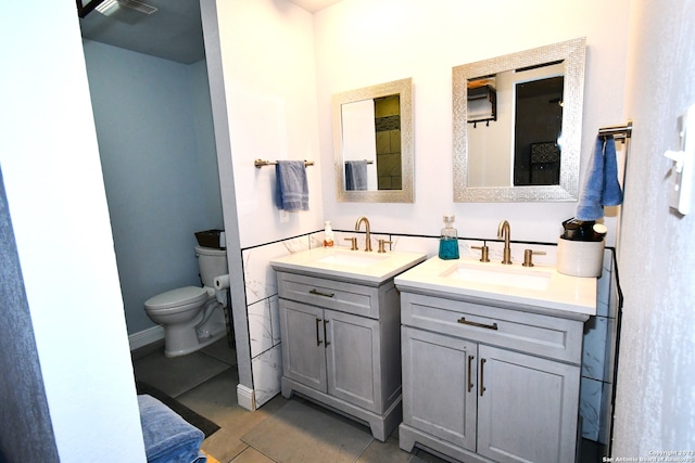 bathroom with dual vanity, tile flooring, and toilet