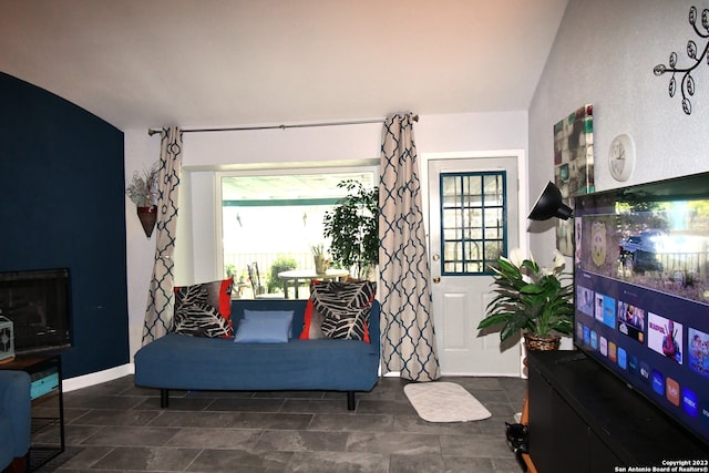 living room featuring lofted ceiling and dark tile flooring