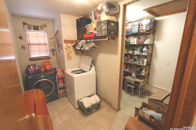 laundry room with light tile floors and washing machine and clothes dryer