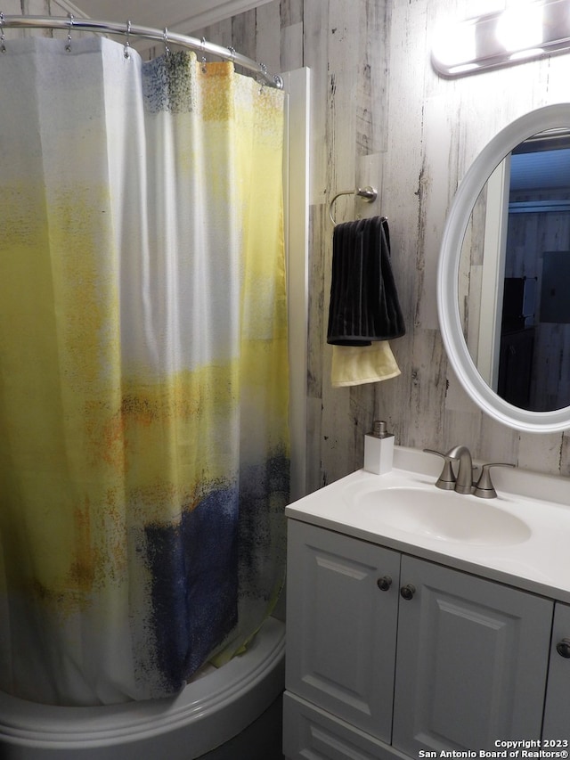 bathroom with vanity with extensive cabinet space and wood walls